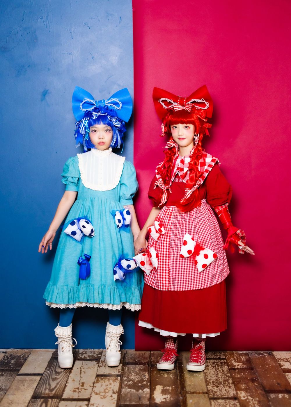 青と赤の衣装で並んで立つ二人の作品写真